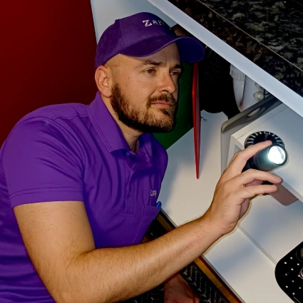 Dale looking in cupboard for cockroaches.