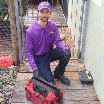 Image of Robert maintaining a rodent station. 
